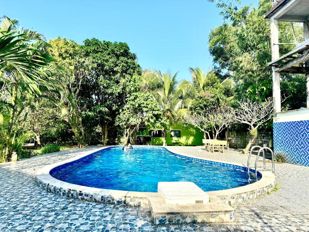 - une piscine dans un complexe avec un banc et des arbres dans l'établissement Bungalow Tina, à Duong Dong