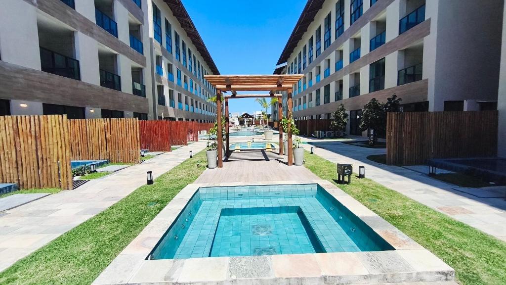 une piscine au milieu d'un immeuble dans l'établissement Max Carneiros Suítes - Com e sem piscina privativa, à Praia dos Carneiros