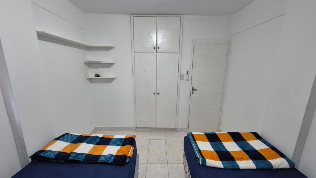 een witte kamer met een bed en een kast bij Apartmento en Encarnación in Encarnación