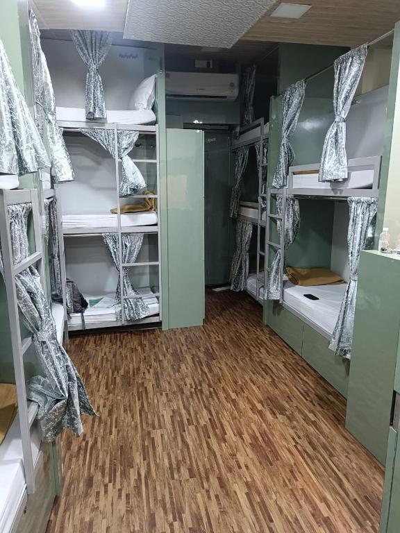 a room with several bunk beds with wood floors at Goldsport Dormitory in Jāmb