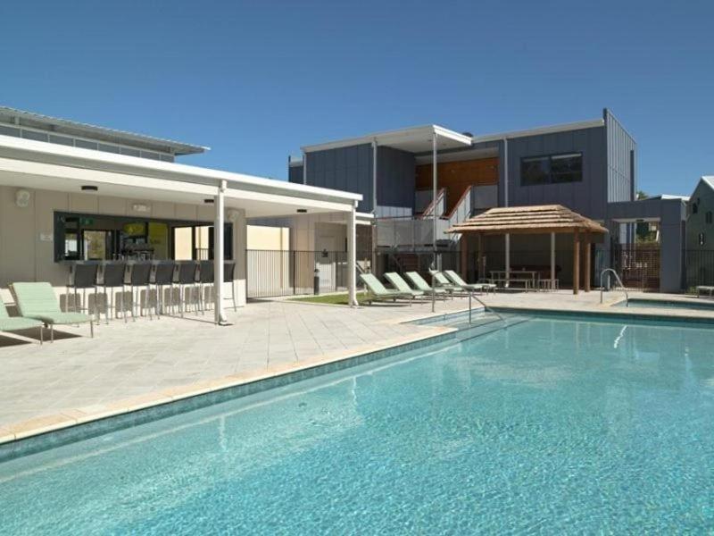 a large swimming pool in front of a building at Frangipanis at Footprints in Preston Beach
