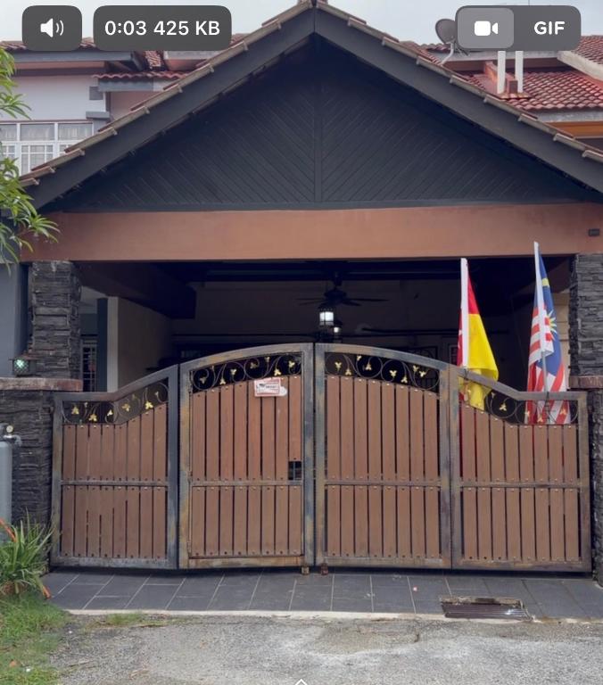 a garage with a gate with two flags in it at Zuma Homestay in Sungai Buluh