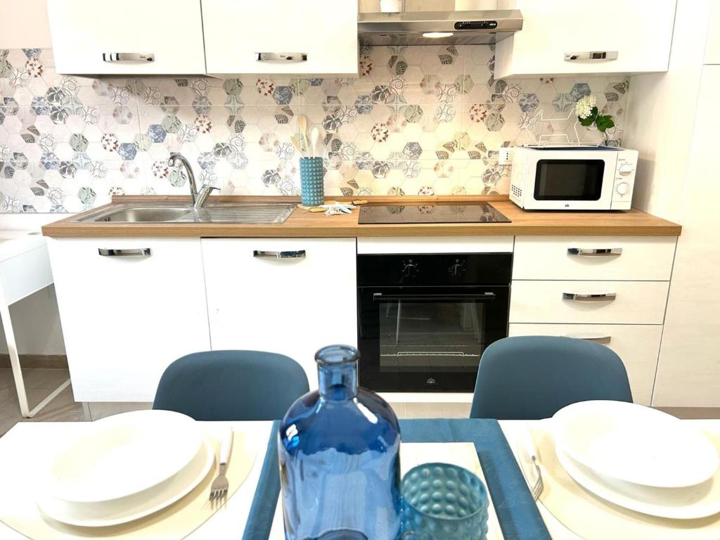 eine Küche mit einem Tisch und einer blauen Flasche darauf in der Unterkunft Apartment in Sassari in Trinità dʼAgultu