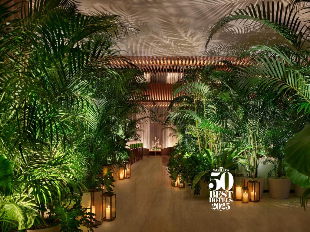 a lobby filled with lots of plants and lights at The Tokyo EDITION, Toranomon in Tokyo