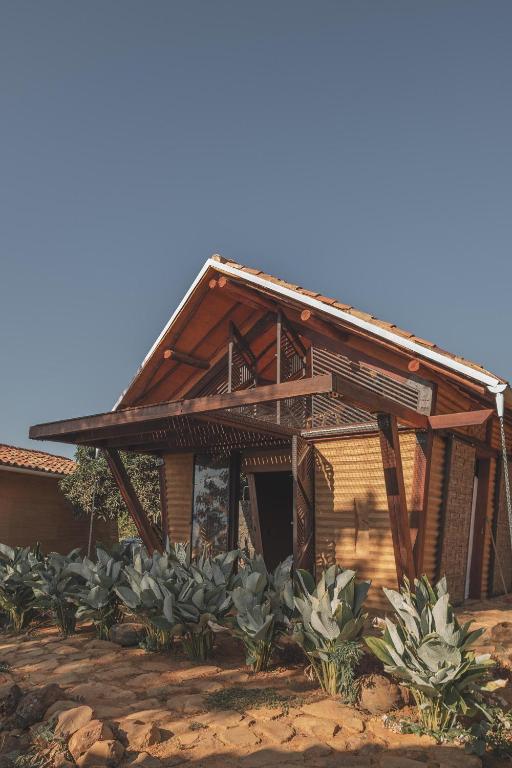 a wooden house with plants in front of it at Hotel Ambil in Barichara