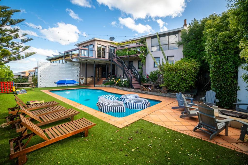 a backyard with a swimming pool with chairs and a house at The Yard - Comfortable Home in Riverside in Inveresk