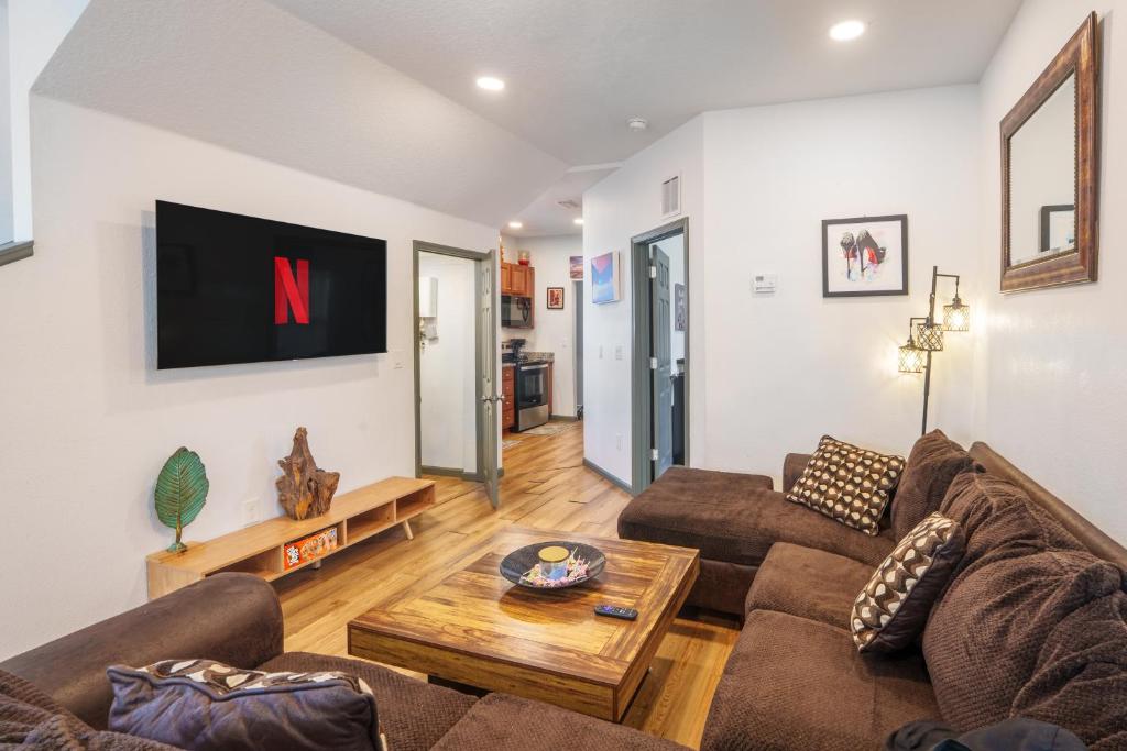 a living room with a couch and a tv on the wall at Stylish & Quiet 3BD Sleeps 8 Near Stadium & Downtown in Jacksonville