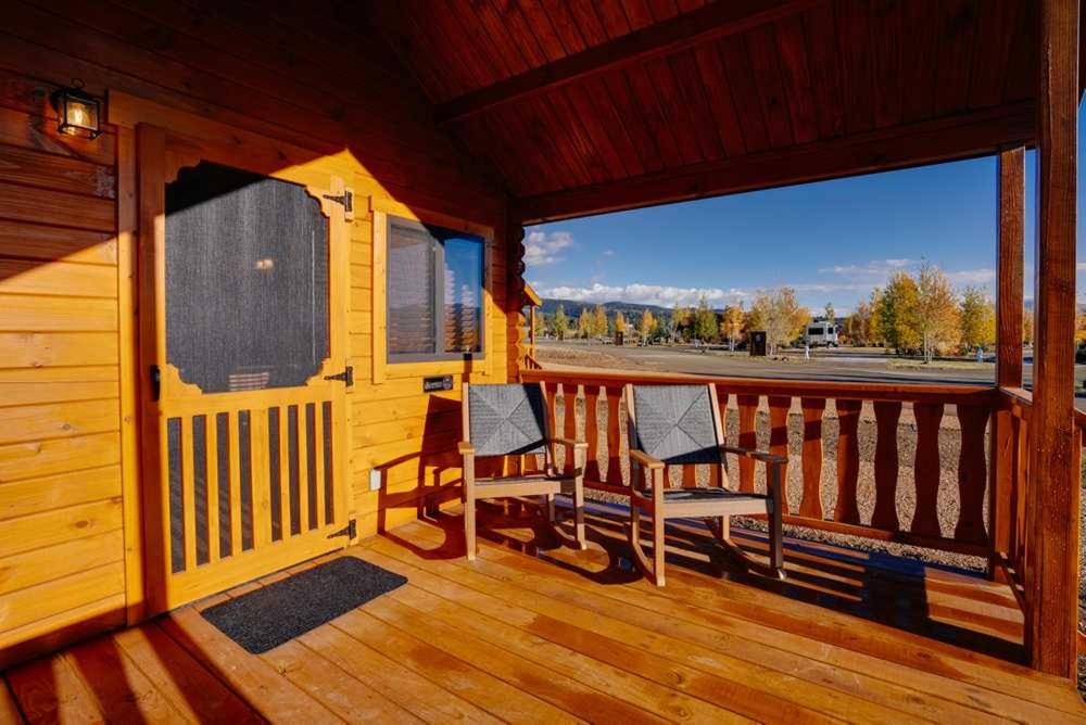 two chairs sitting on the porch of a cabin at Angel Fire RV Resort in Angel Fire