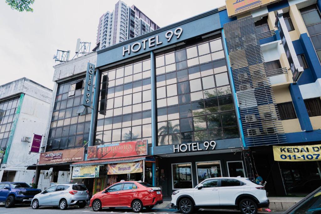 a building with cars parked in front of it at Hotel 99 Seri Kembangan Serdang in Seri Kembangan