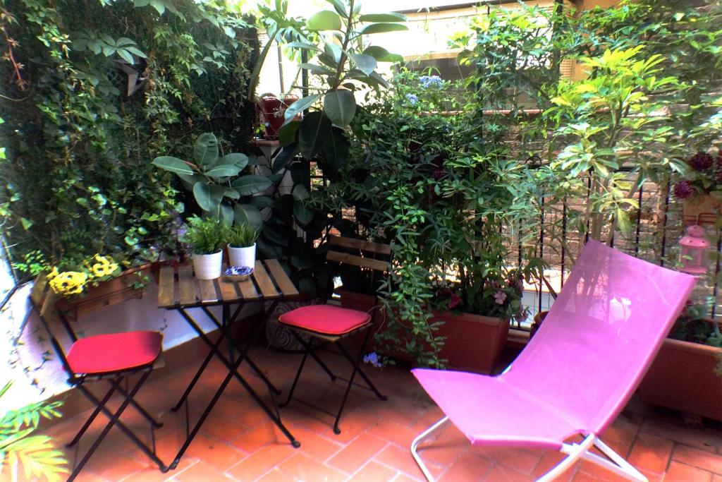 een patio met 2 stoelen en een tafel met planten bij Casa Tortilla Gracia in Barcelona