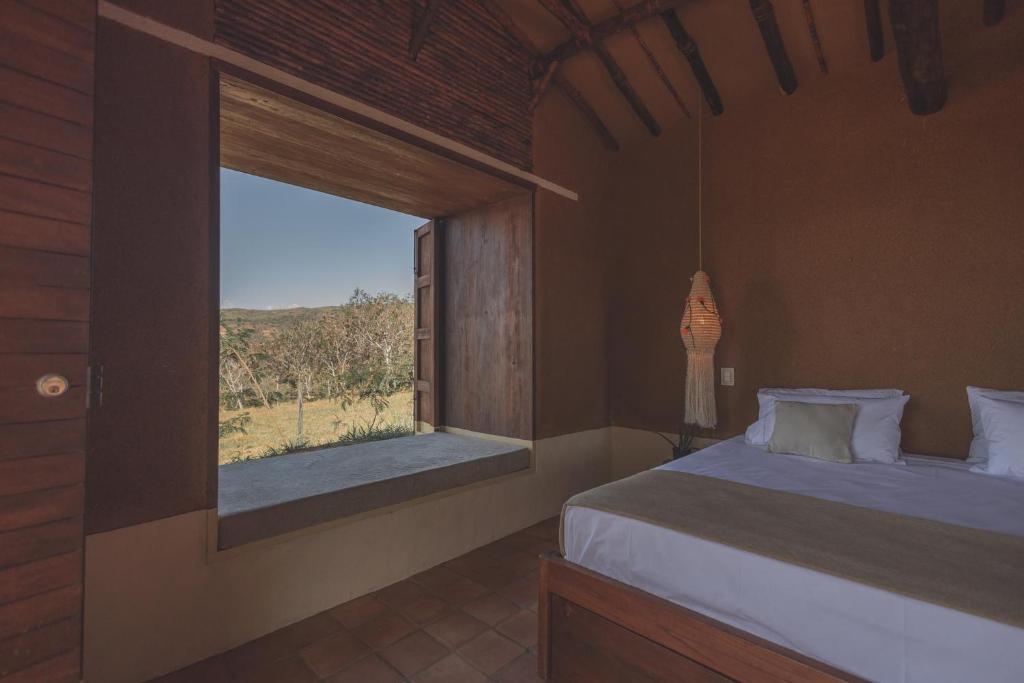une chambre avec un lit et une grande fenêtre dans l'établissement Hotel Ambil, à Barichara