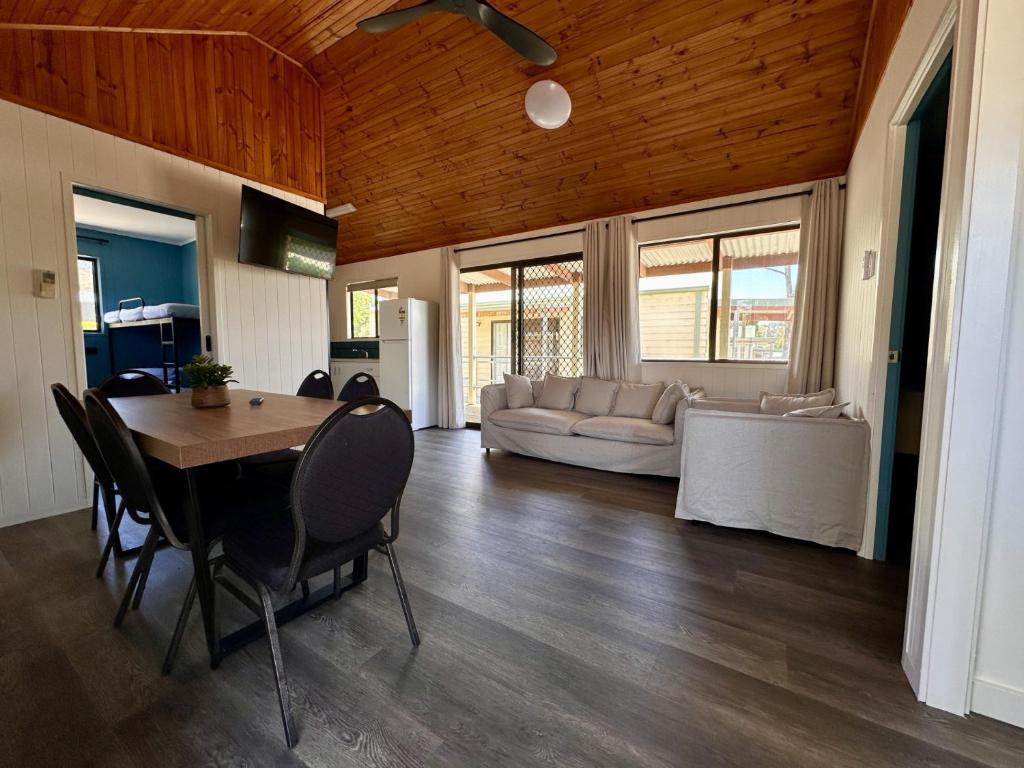 une salle à manger et un salon avec une table et des chaises dans l'établissement Eaglehawk Park Canberra, à Canberra