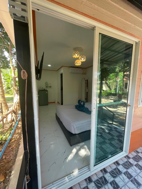 a room with a bed and a sliding glass door at Vannana House Ko Lanta in Ko Lanta