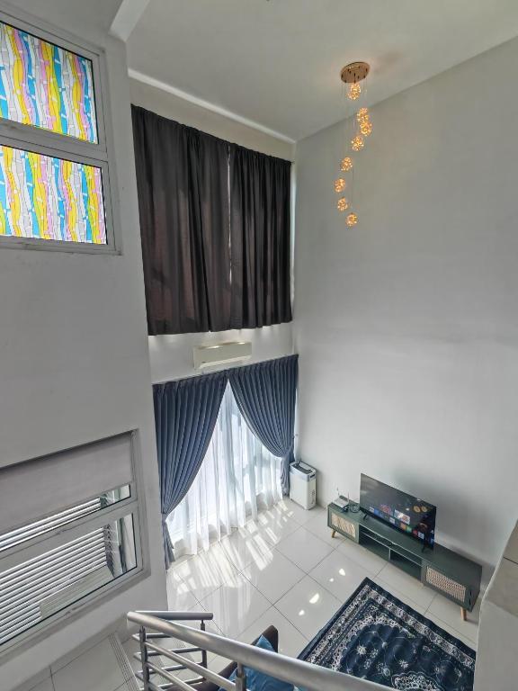 a living room with a large window and a chandelier at De Centrum Residences in Kajang