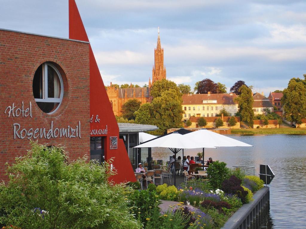 a restaurant next to a body of water with a building at Rosendomizil in Malchow