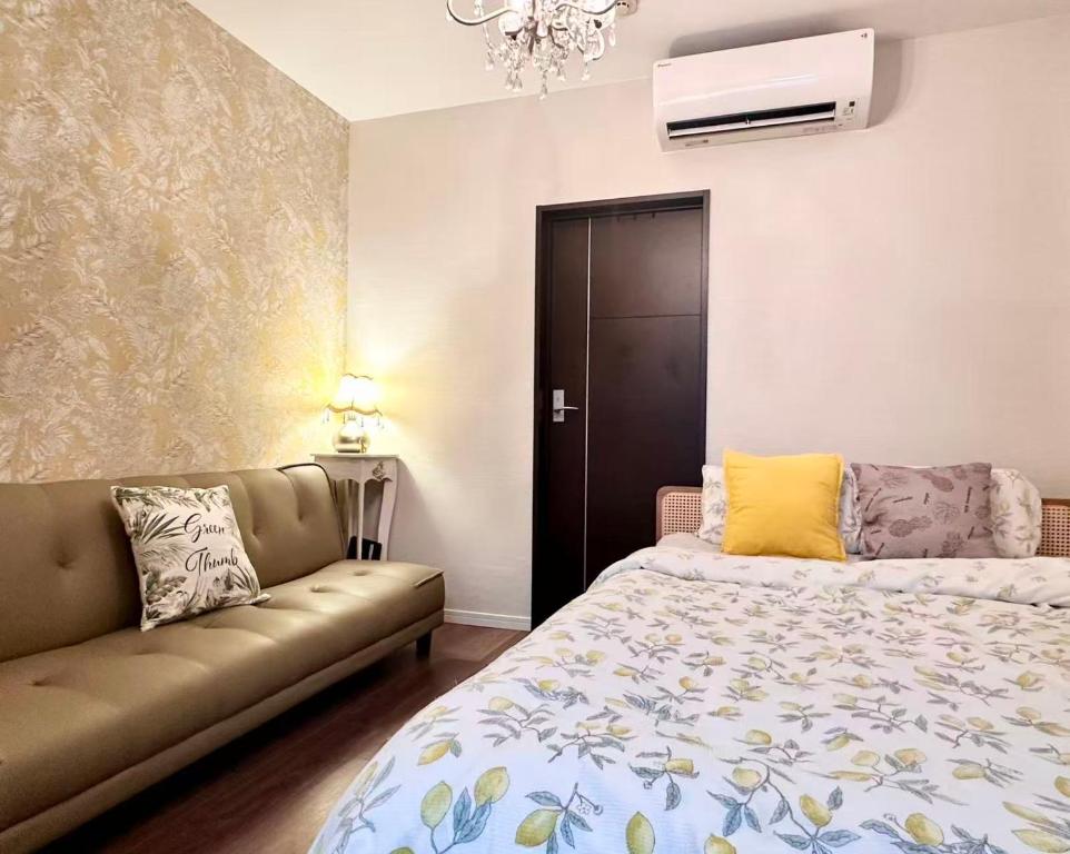 ein Schlafzimmer mit einem Bett und einer Couch in der Unterkunft Mori de house in kobe 2 in Kōbe