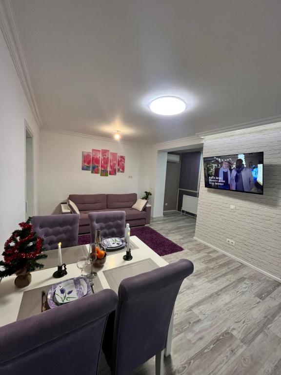 ein Wohnzimmer mit einem Tisch und einem Sofa in der Unterkunft Spacious apartment with a beautiful view in Căuşeni