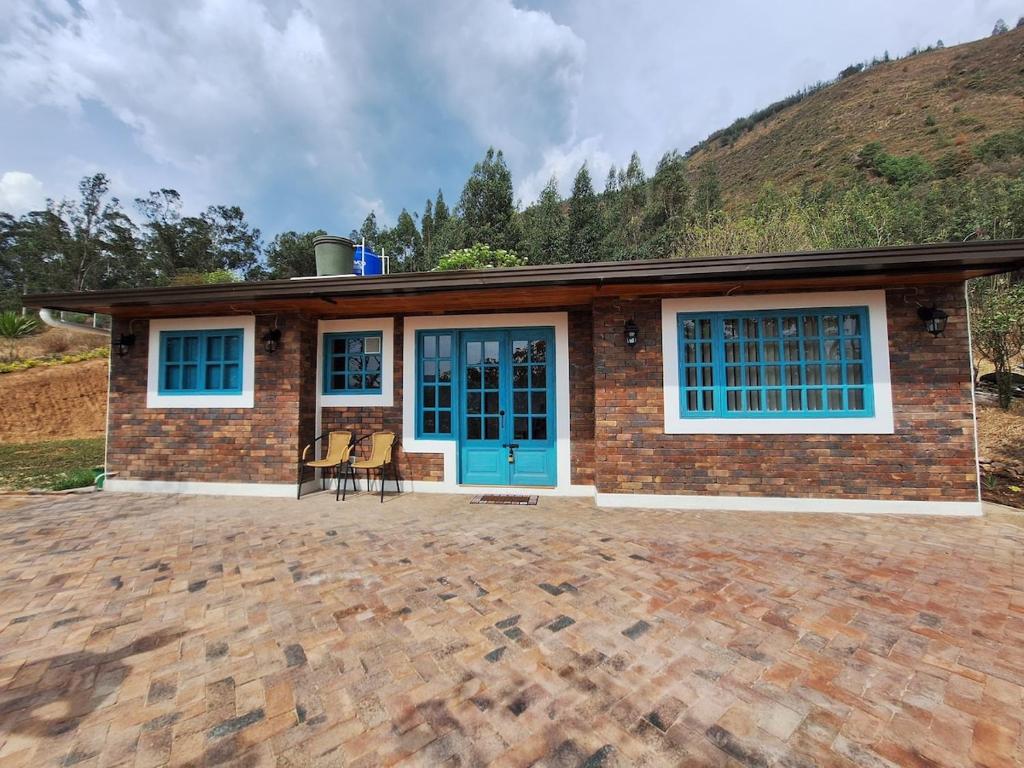 a brick house with a blue door at El Embeleso in Nobsa