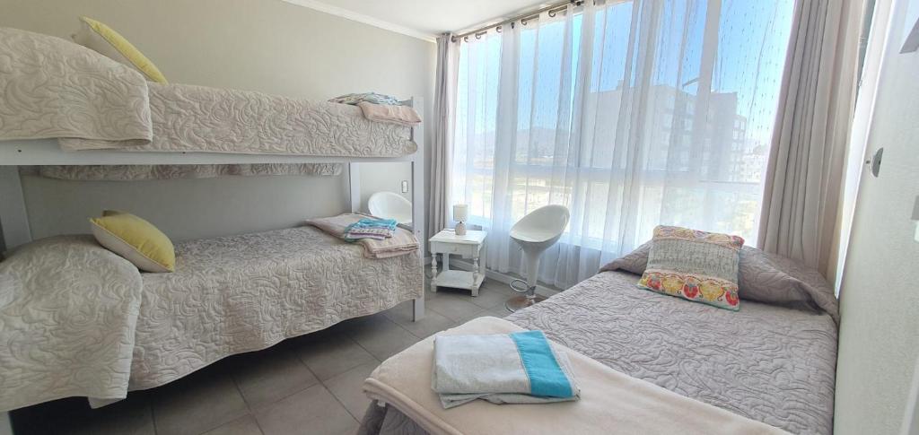 een slaapkamer met twee stapelbedden en een raam bij II Cerca de la playa y del centro in La Serena