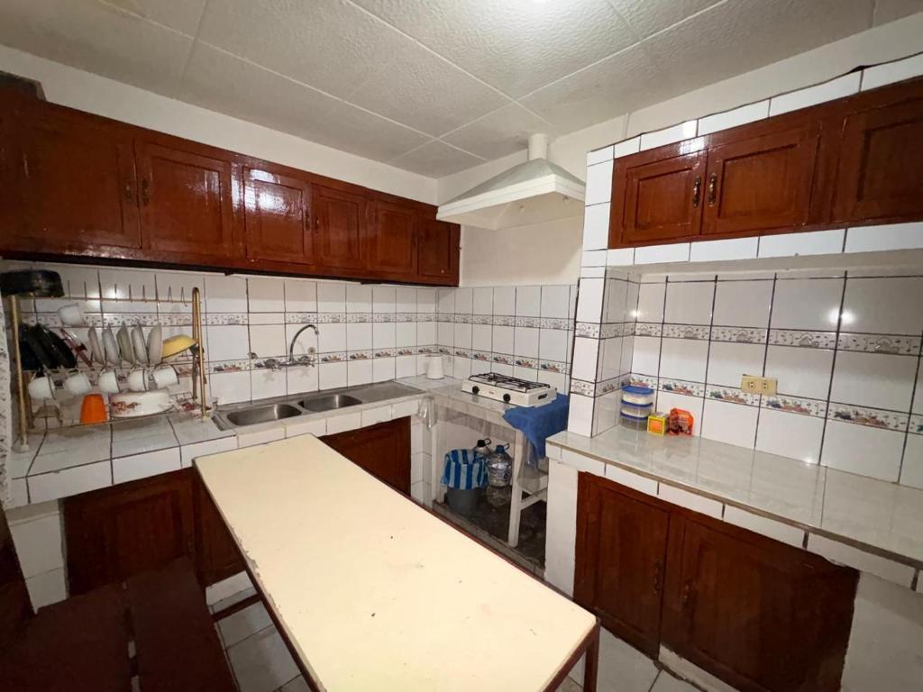 een keuken met houten kasten en een aanrechtblad bij Aquisito Nomas Es in Cuenca