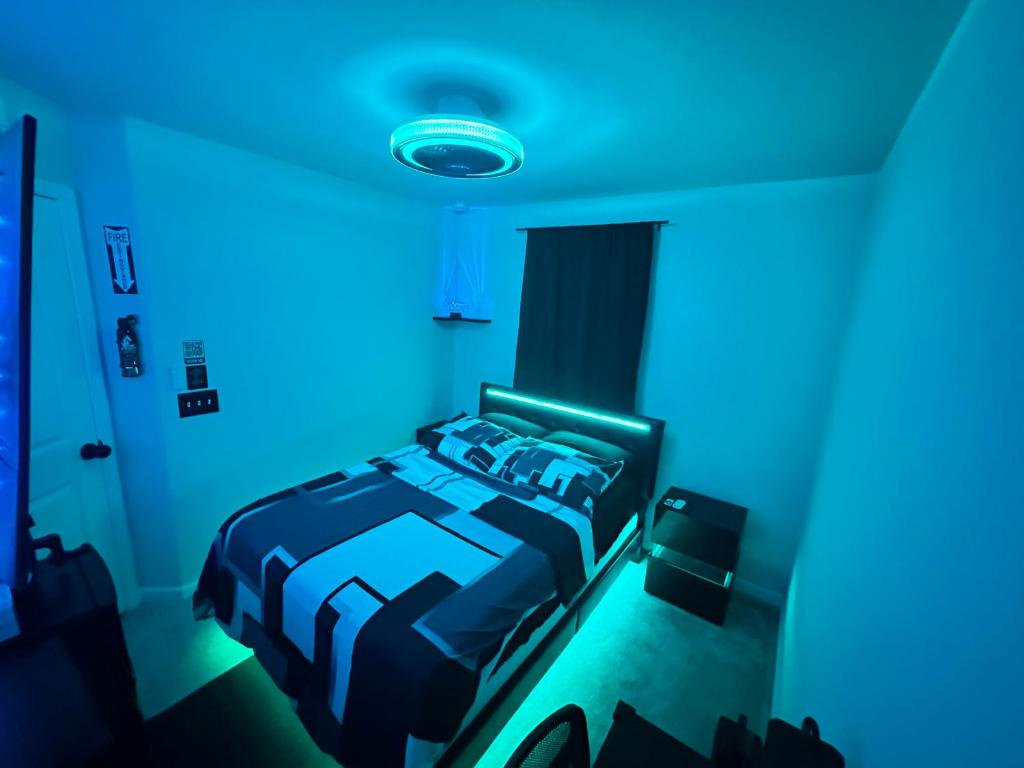 una camera da letto con un letto con luci blu di Modern Theme Private Room a Suffolk