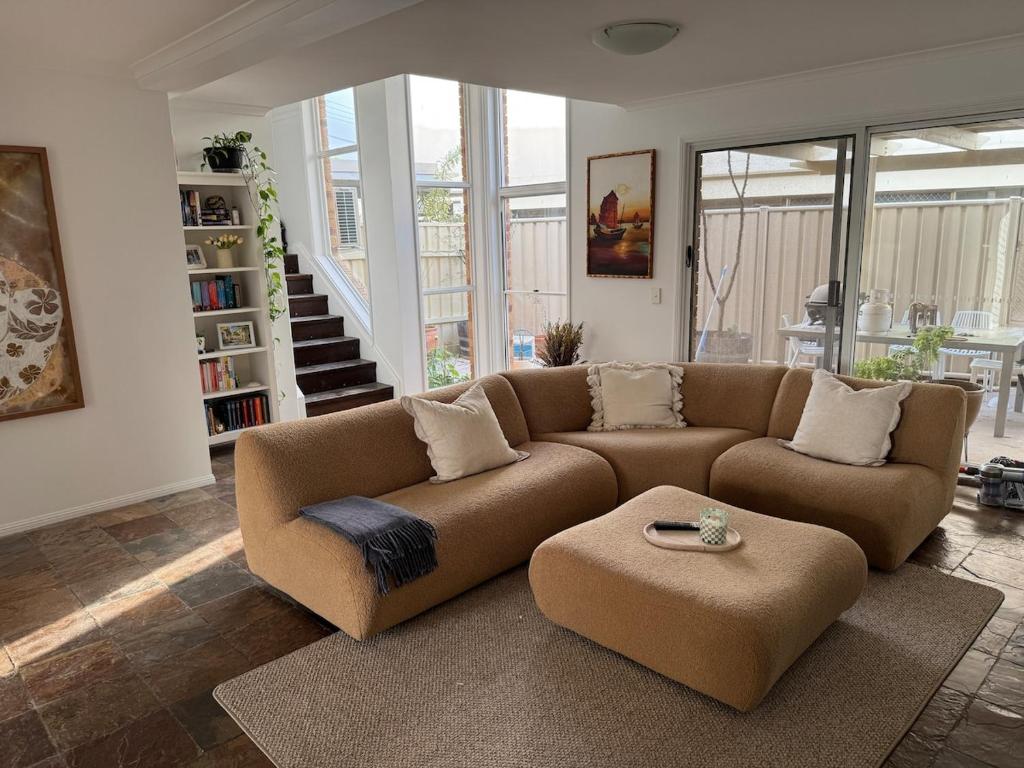 un soggiorno con un divano marrone e un tavolo di The Mooloolaba Terrace a Mooloolaba