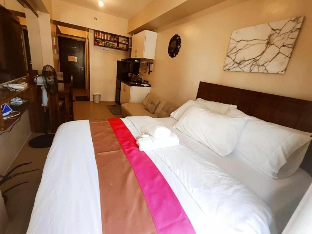 a bedroom with a large bed with two towels on it at 316 Tower 3 Avida Atria Iloilo Pool View Comfy Cozy Central in Iloilo City