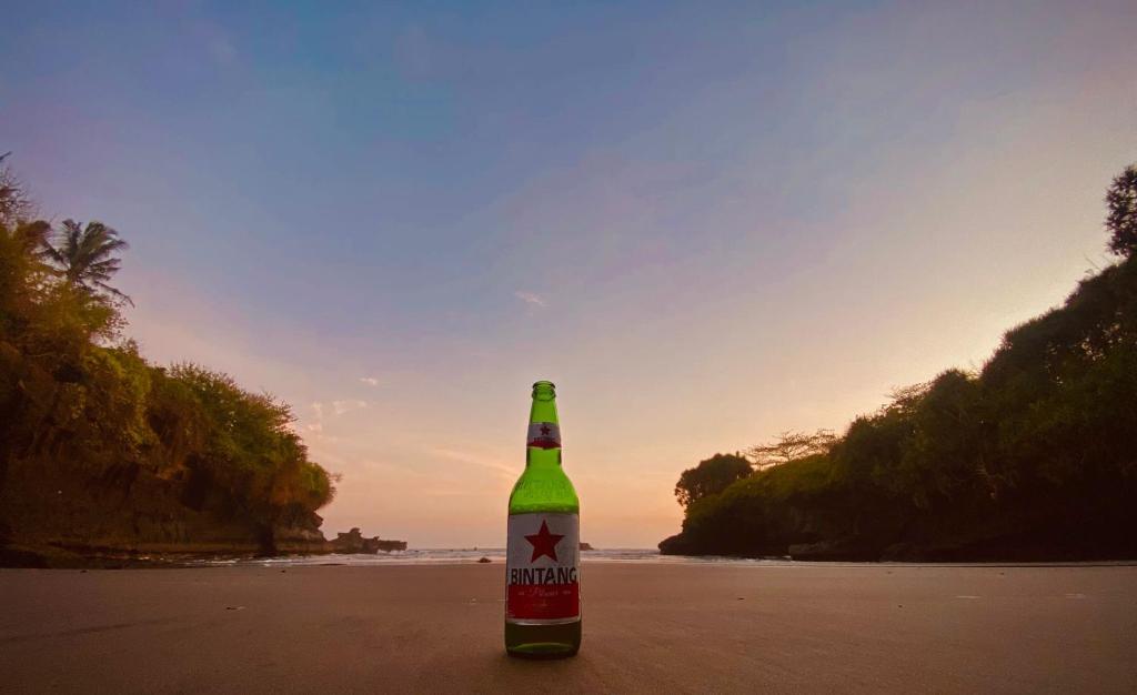 een flesje bier op het strand bij Clover Cove Villa in Tabanan