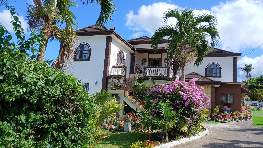 a house with palm trees and flowers in front of it at Mandeville Hideaway in Mandeville