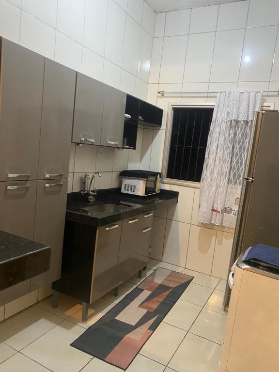 a small kitchen with a sink and a refrigerator at Casa completa com dois quartos e estacionamento grátis in Serra