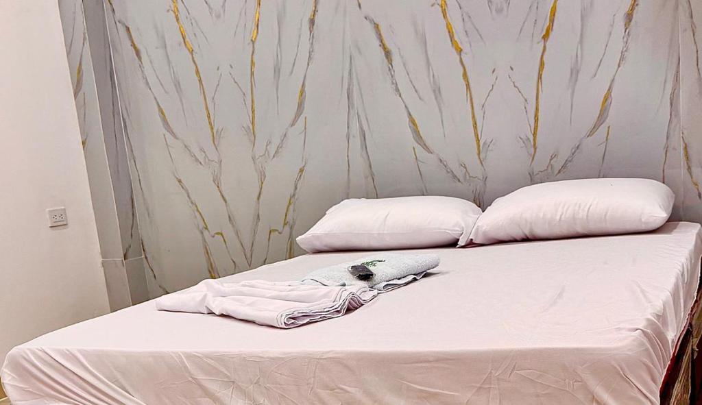 ein Bett mit zwei Kissen und einem Bademantel. in der Unterkunft Haití Hotel B in Tumaco