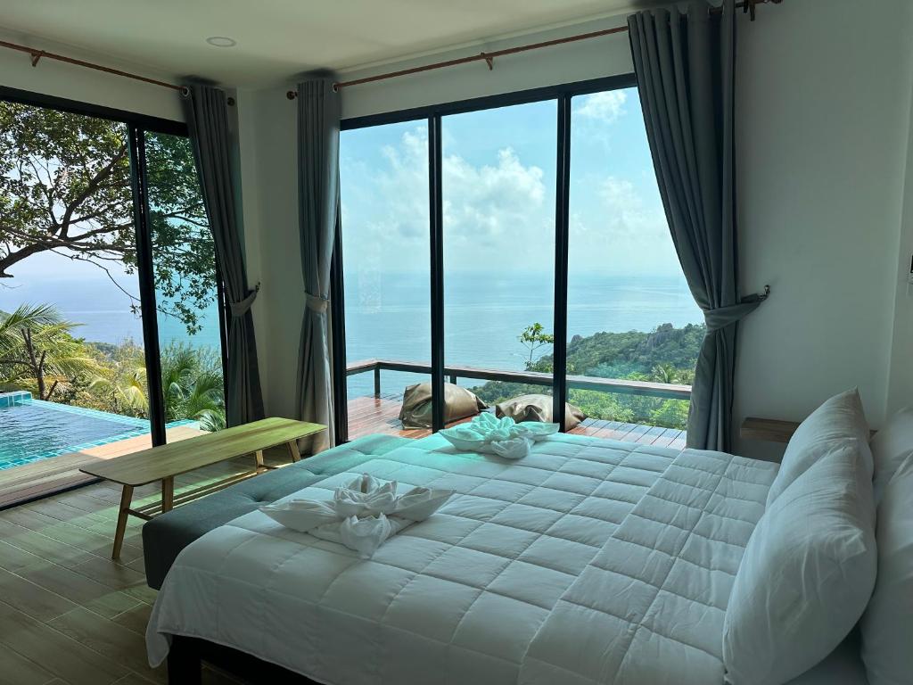 a bedroom with a bed and a view of the ocean at Love koh tao villa 2 in Koh Tao