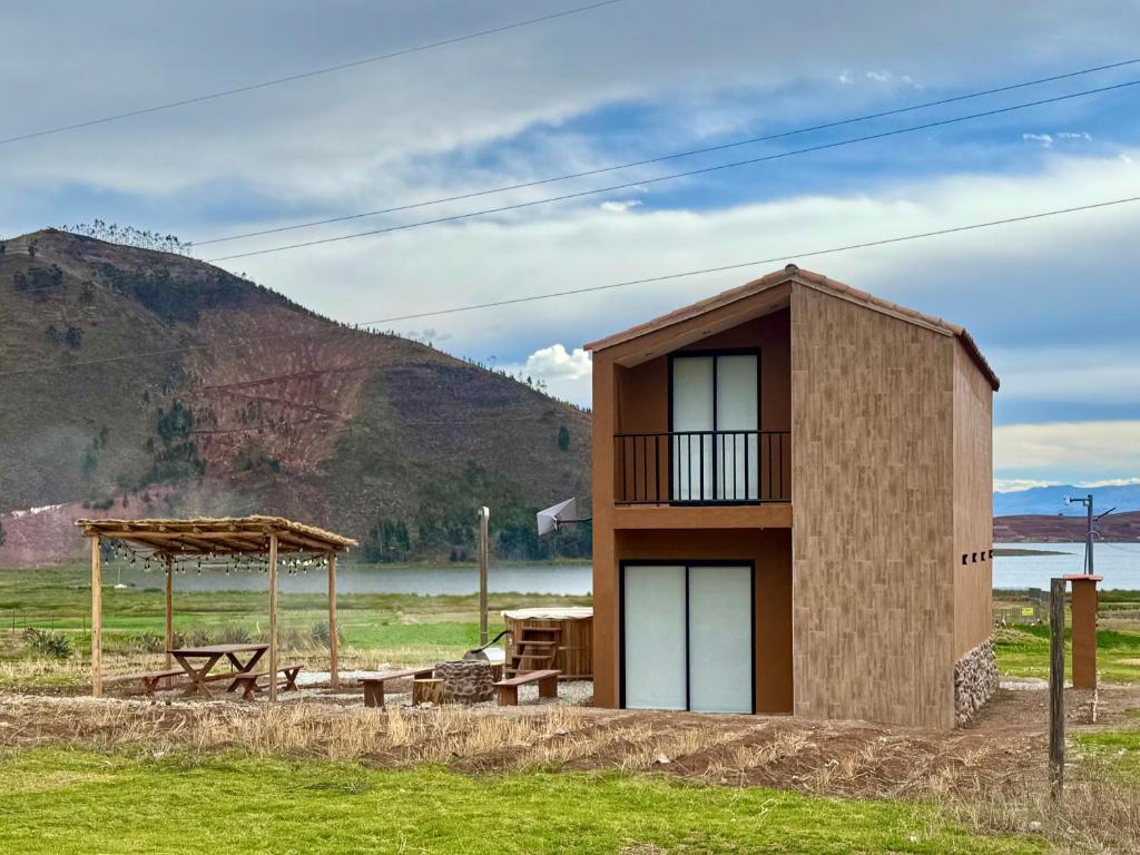 a small building next to a picnic table and a hill at Tiny House con Jacuzzi, Fogata y Starlink in Anta