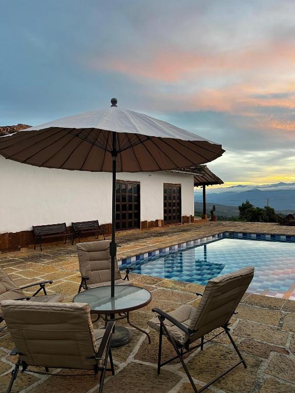a table with an umbrella next to a swimming pool at Cabaña VillaMaria in Villanueva