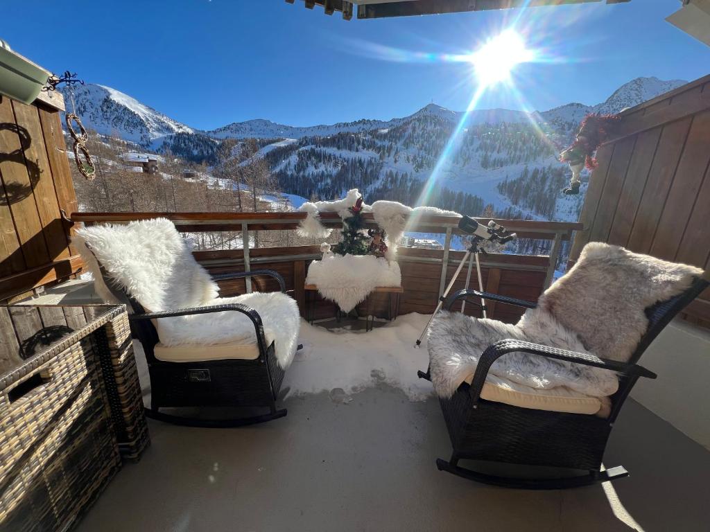 2 stoelen op een balkon met uitzicht op een berg bij 5 personnes, 2Pieces exceptionnel havre de détente et de confort, immense terrasse, vue incroyable, Tout pédestre, à 10m du funiculaire, parking in Isola 2000