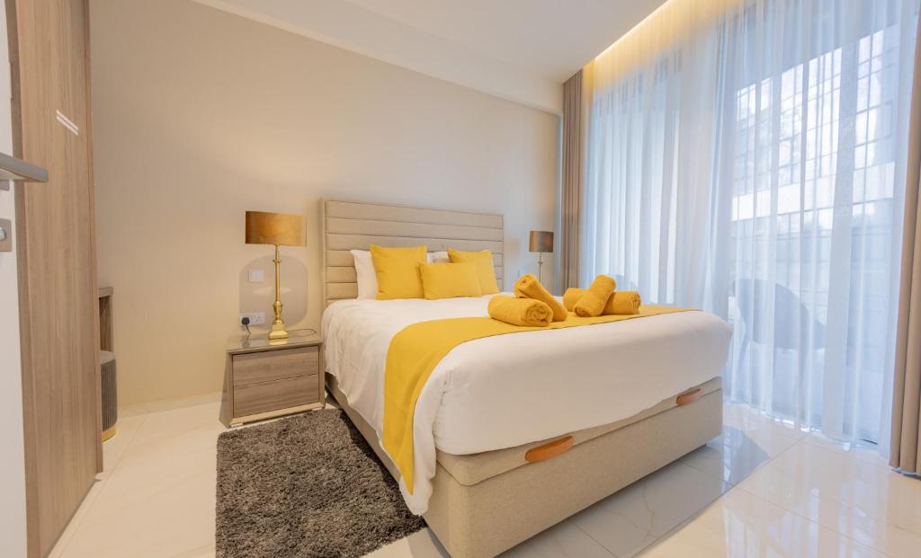 una camera da letto con un letto grande con cuscini gialli di Mercury Tower Apt 508 a San Giuliano
