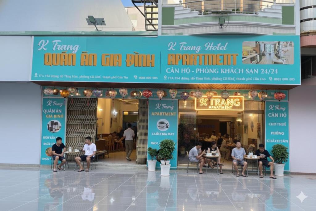 eine Gruppe von Personen, die außerhalb eines Restaurants an Tischen sitzen in der Unterkunft Khách sạn K-Trang APARTMENT in Cần Thơ