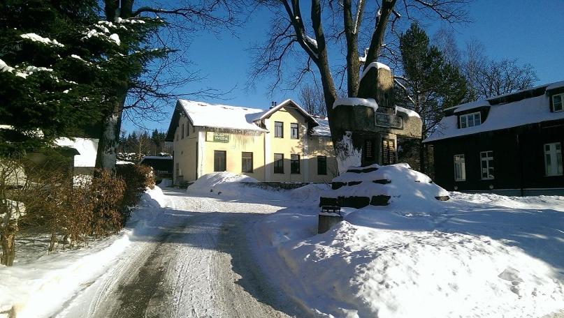 ulica pokryta śniegiem przed domem w obiekcie Hvězda Apartments w mieście Harrachov