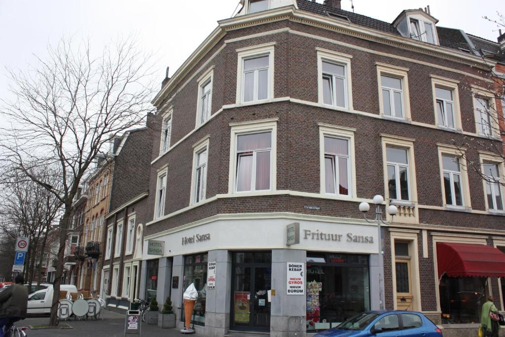 a large brick building on a city street at Hotel Sansa in Maastricht