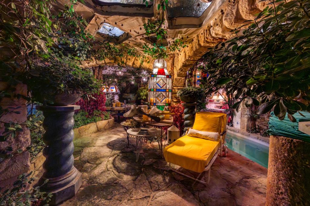 a room filled with lots of plants and a yellow couch at Romantic Provence Pool & Mill View in Goult