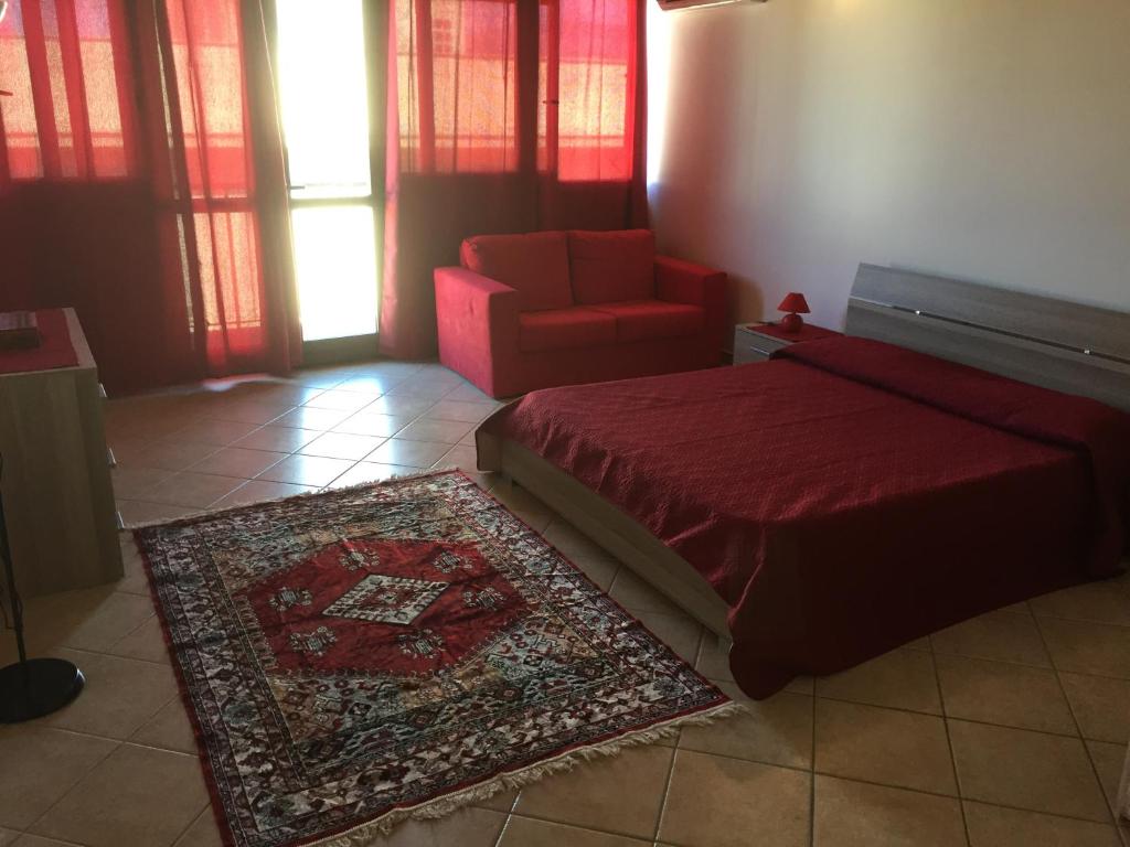 バレストラーテにあるRoby Suite Homeのリビングルーム(ベッド1台、赤い椅子付)