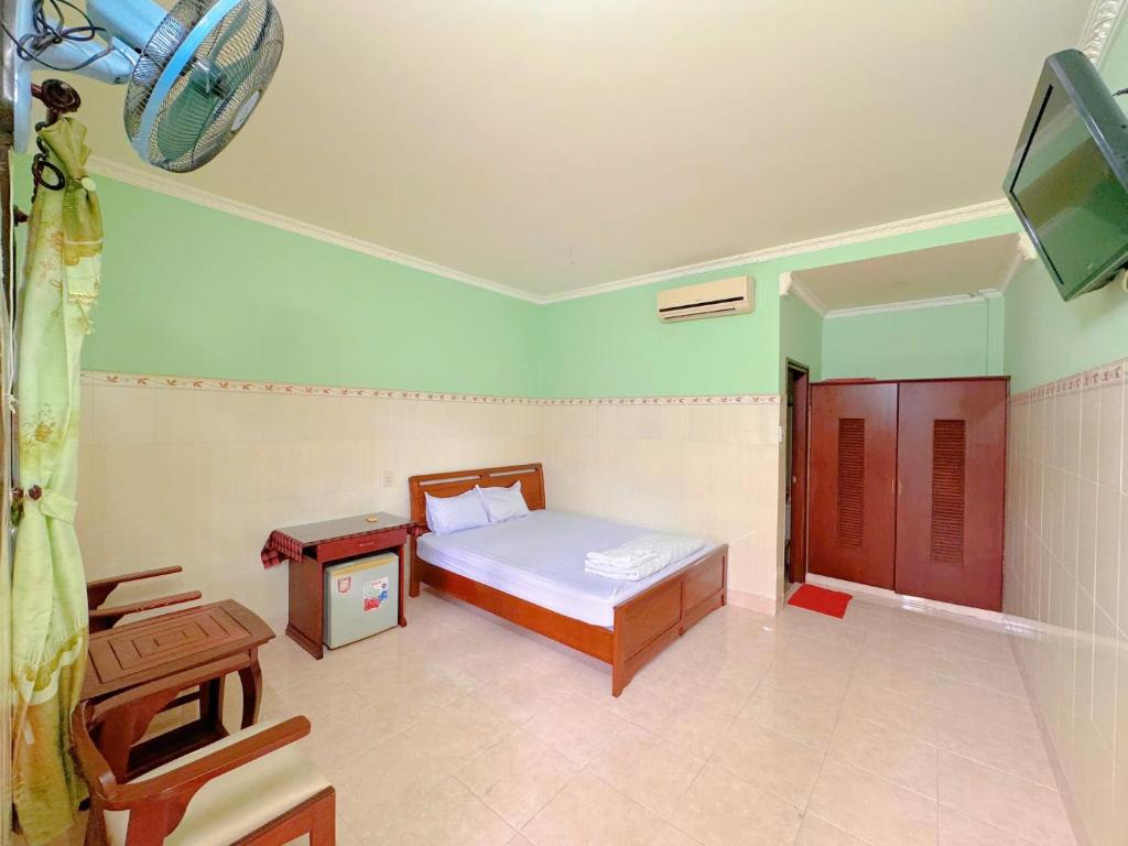 een slaapkamer met een bed en een tv erin bij Anh Linh Guest House in Mũi Né