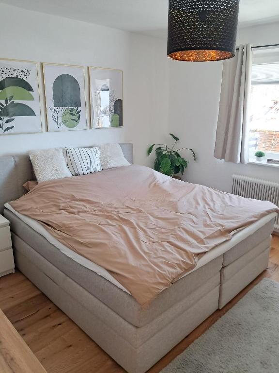 ein Bett in einem weißen Schlafzimmer mit einem großen Bett in der Unterkunft Das Litzldorf in Sankt Michael im Lungau