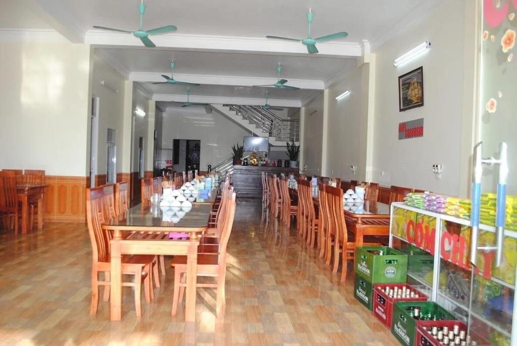 a dining room with a table and wooden chairs at Hotel Thi Hoa Bai Dinh in Ninh Binh