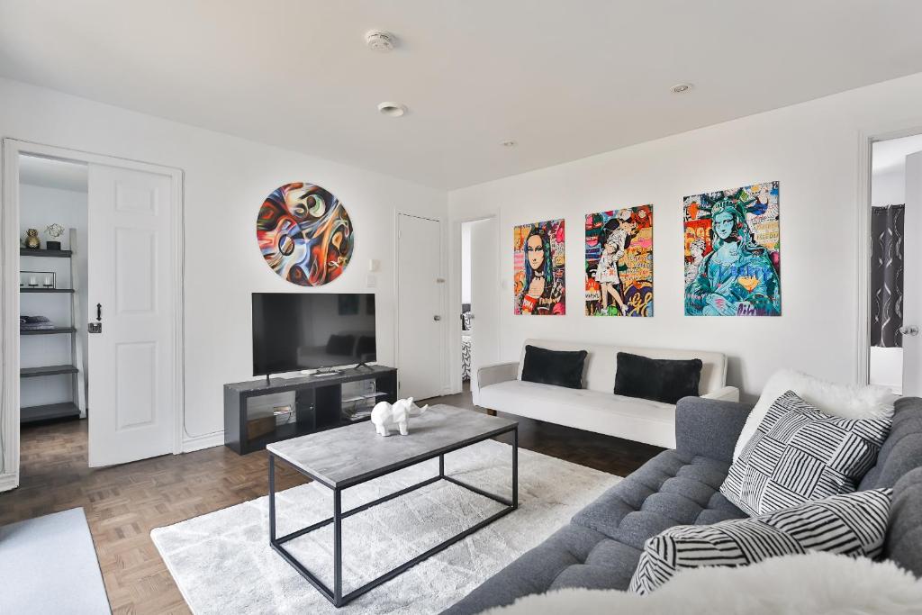 a living room with a couch and a table at FREE PARKING - In-Suite WASHER & DRYER - fully stocked KITCHEN - WORKSPACE PROVIDED - FAST WIFI - 5 minute walk to the most CENTRAL metro station IN MONTREAL - BERRI UQAM in Montréal
