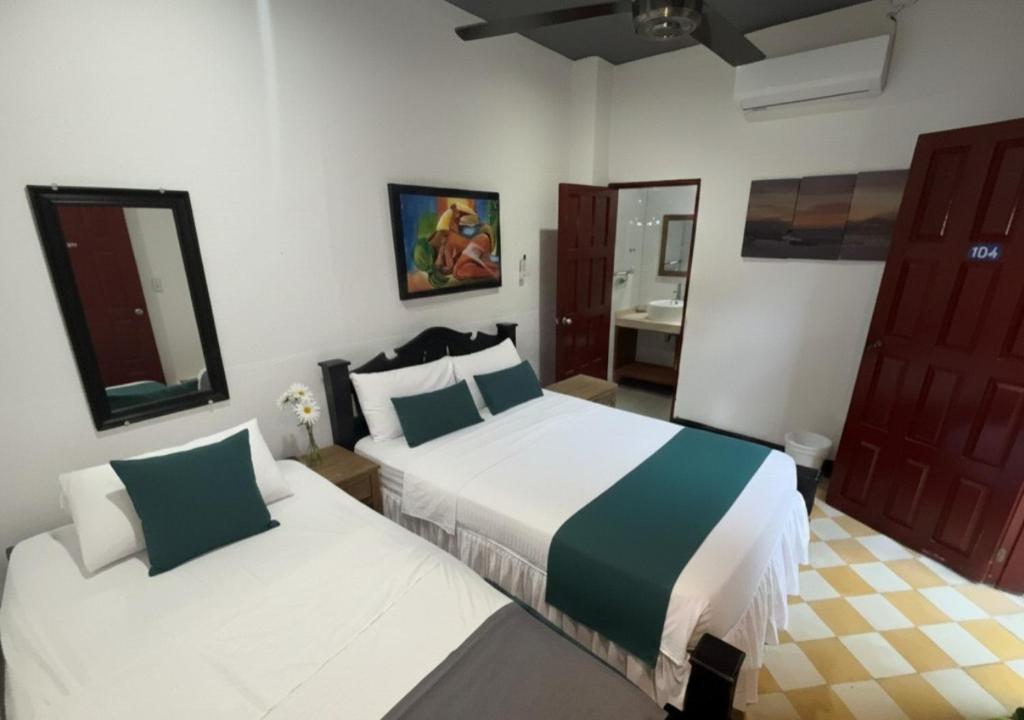 een slaapkamer met 2 bedden en een badkamer bij Hotel Casa de Sarah in Santa Marta