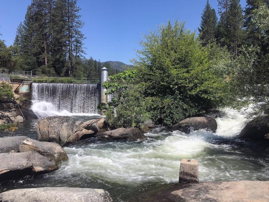 a waterfall in a river with rocks and trees at Cedar Springs Retreats in North Fork
