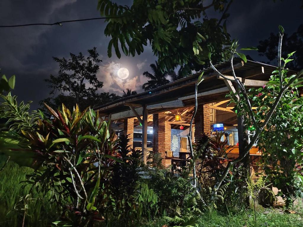 een huis 's nachts met de maan in de lucht bij waroeng bangket in Mantang