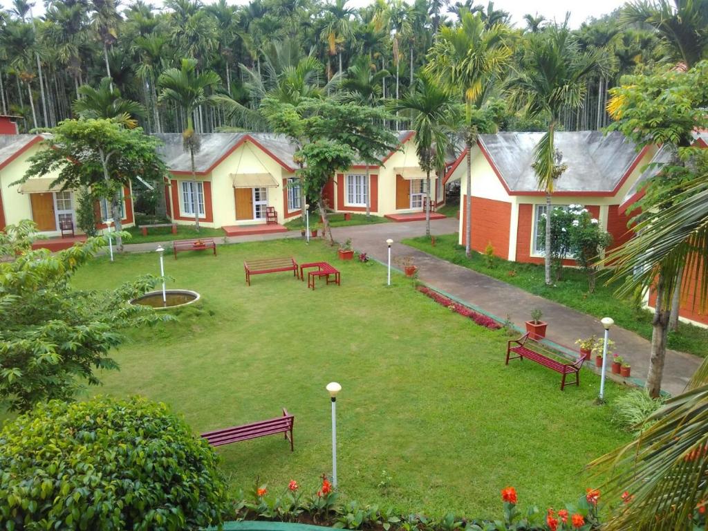 un parque con bancos, árboles y casas en The Casiita Coorg, en Kushālnagar