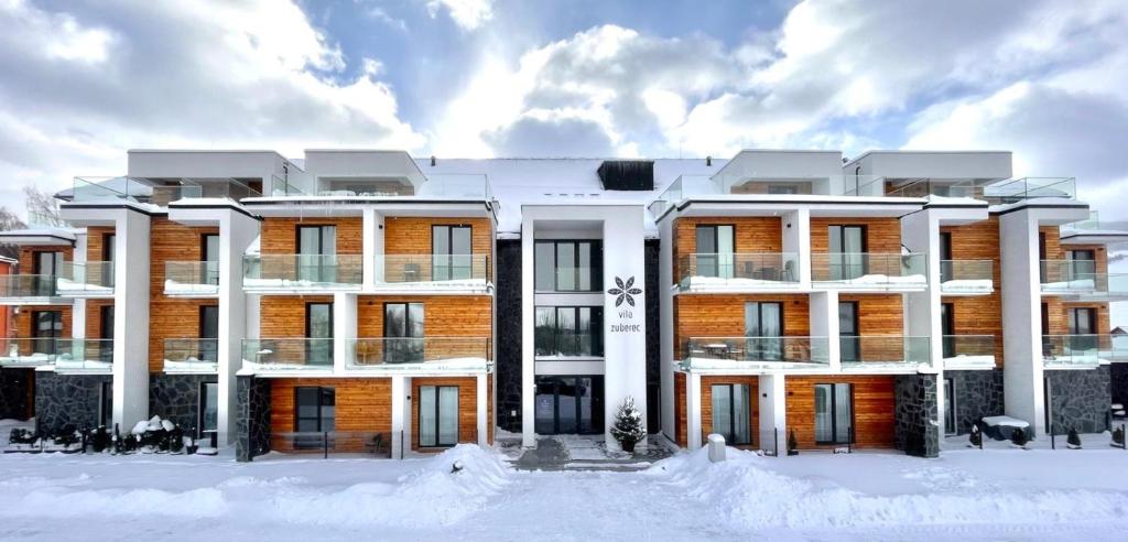 a building with snow in front of it at Apartmán Vila Zuberec in Zuberec